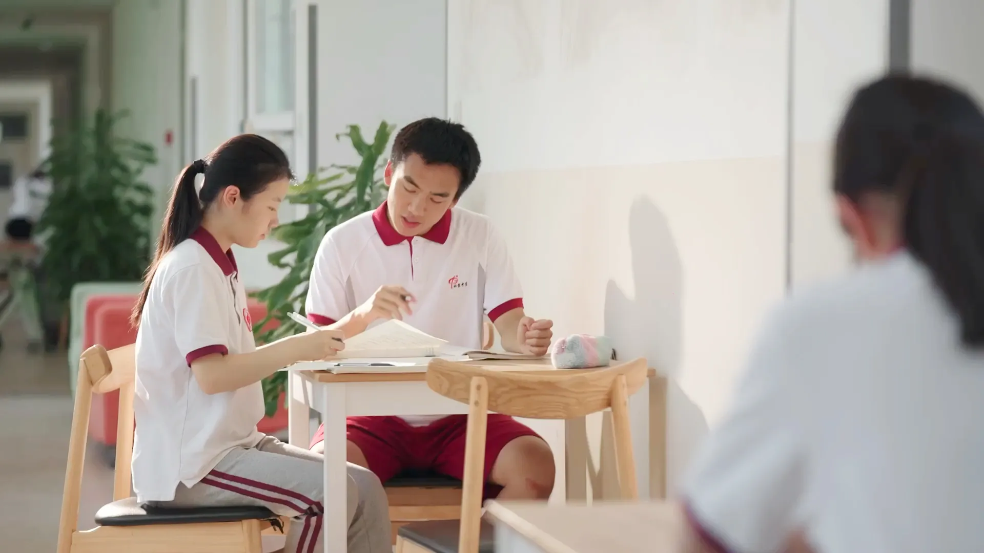 两个北中学生围着书桌在学习