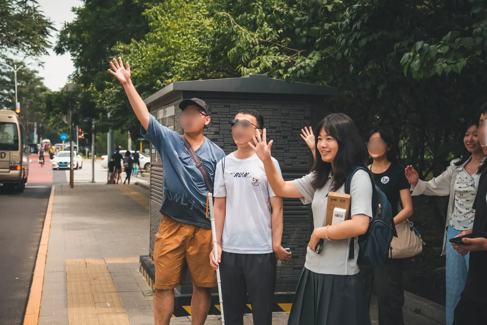 一位北京中学的女同学和其他鹤群公益的视障朋友及志愿者一起举手示意