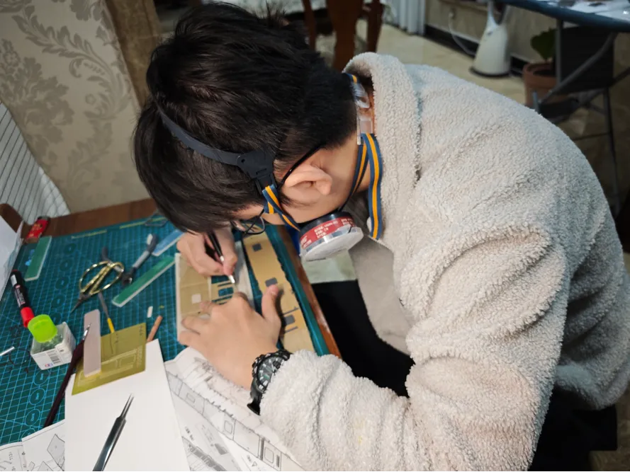 一位同学正在工作台上刻模型