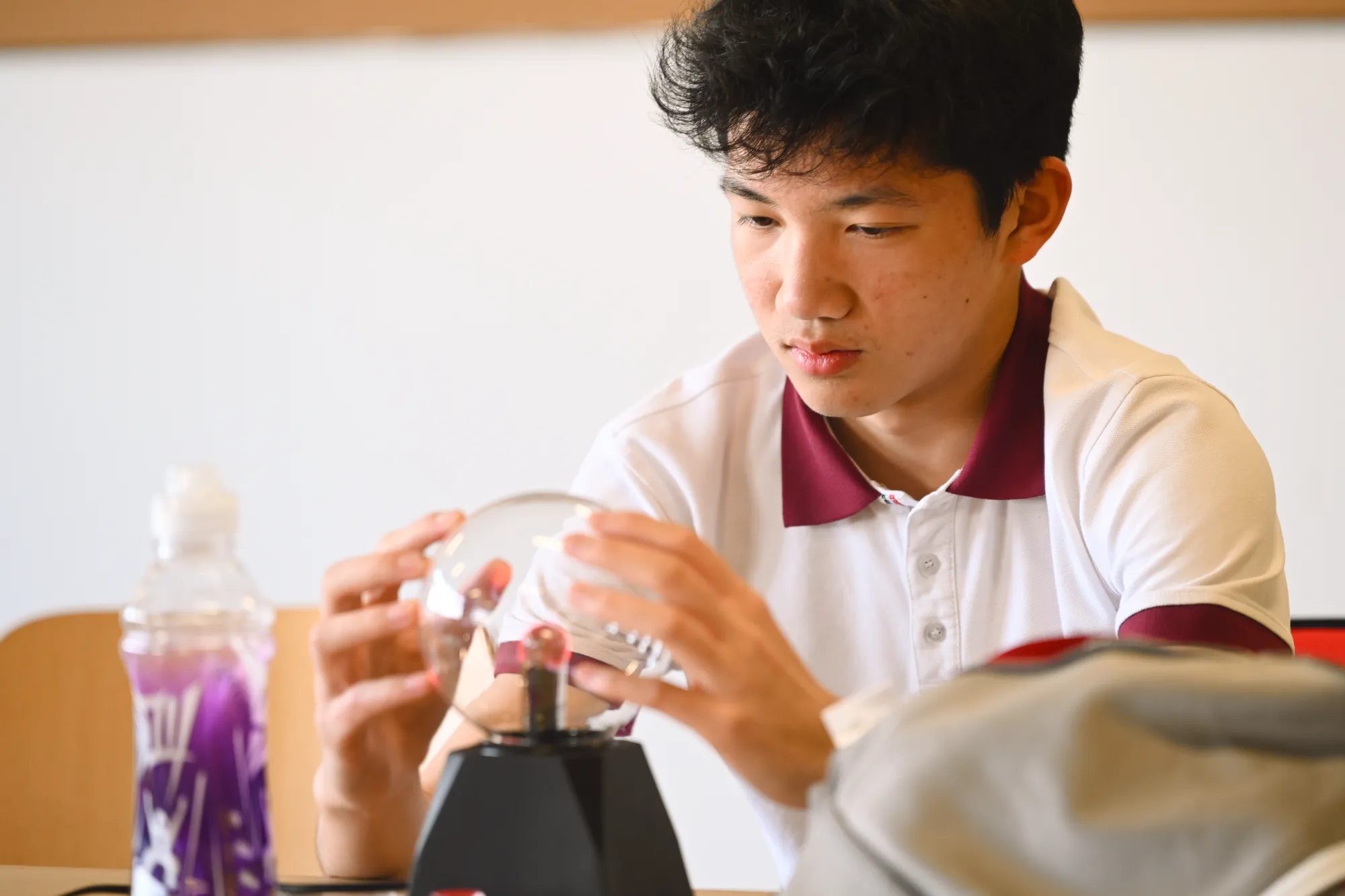 一位男生正在操作一个电灯泡