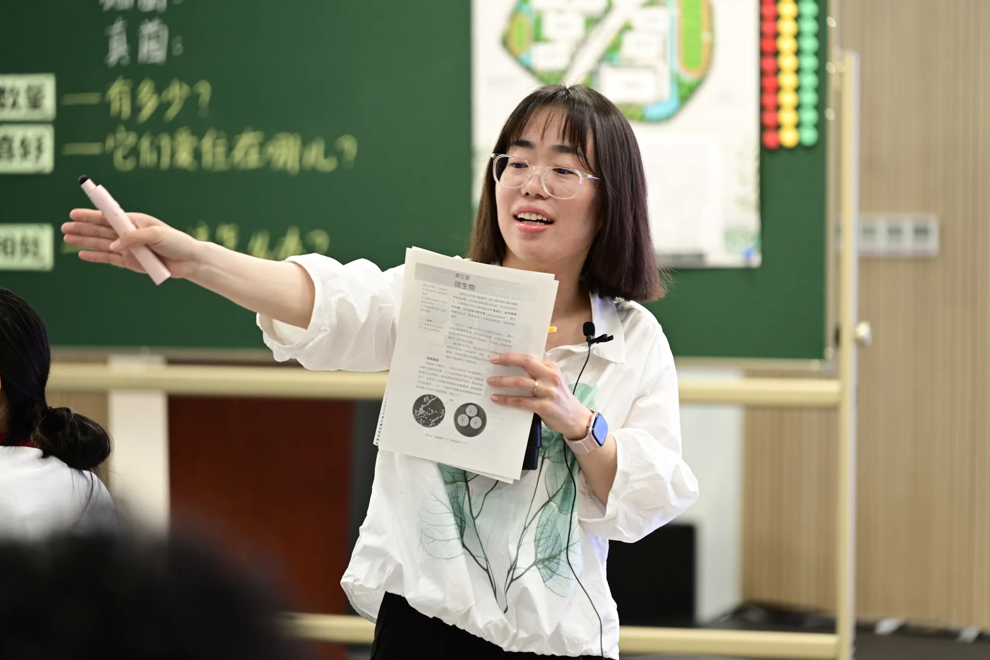 一位女教师伸手请学生回答问题