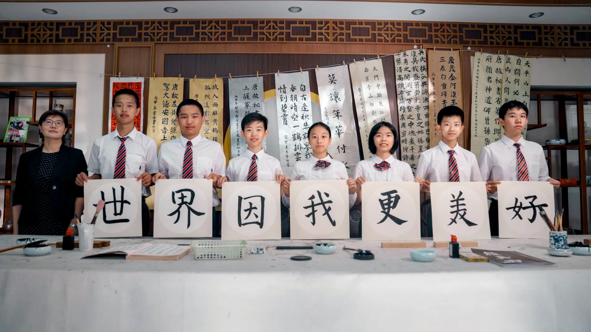 一群人举起写有「世界因我更美好」的书法作品